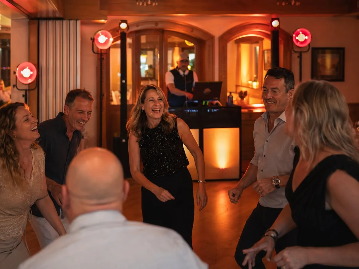 Professioneller DJ begleitet eine Feier mit Gästen auf der Tanzfläche