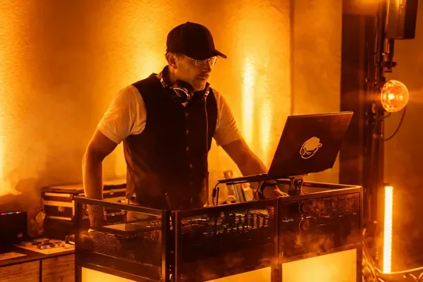 DJ Rico Cinsano am DJ-Pult, Fokus auf Musik bei Firmenfeier