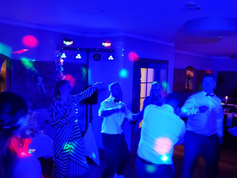 Ausgelassene Tanzszene mit Hochzeitsgästen unter bunten Lichteffekten – Hochzeits DJ Rico Cinsano