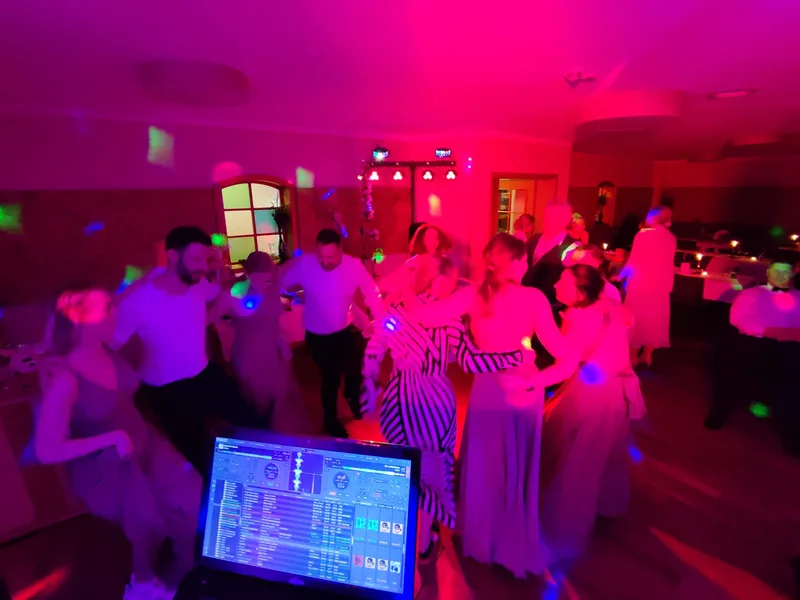 Blick vom DJ-Pult auf vollbesetzte Tanzfläche mit pinkem Licht und tanzenden Gästen – Hochzeits DJ Rico Cinsano