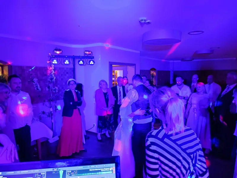 Brautpaar tanzt Eröffnungstanz, Gäste schauen zu, lila Stimmungslicht – Hochzeits DJ Rico Cinsano