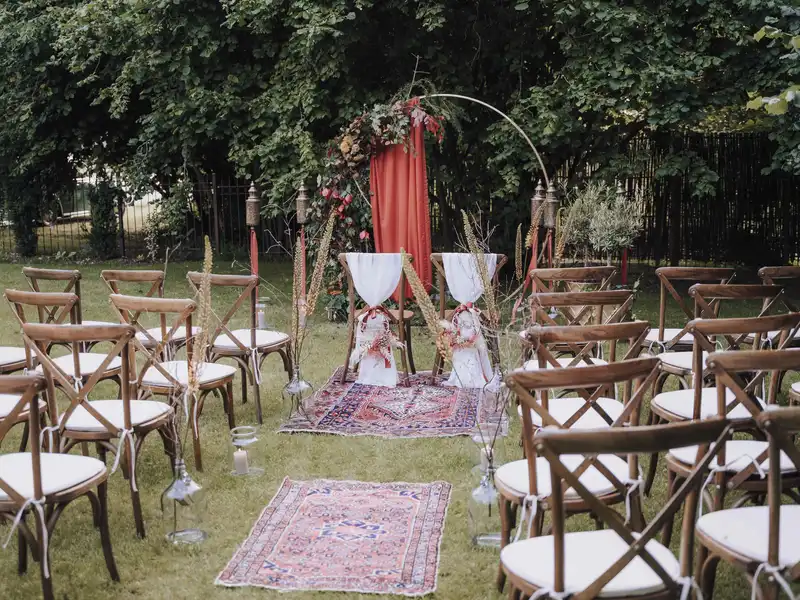 Freie Outdoor-Trauung im Grafenstadl – Boho-Kreisbogen mit rotem Vorhang auf der Gartenwiese