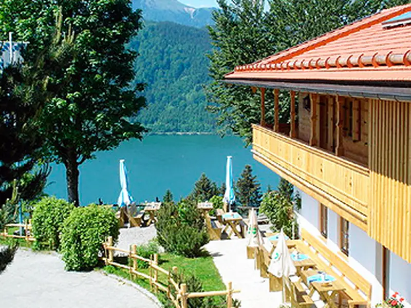 Hochzeits-DJ Stögeralm – Außenansicht der Stögeralm mit Terrasse und Seeblick